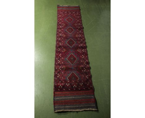 A hand knotted woolen red ground runner, 58cm x 260