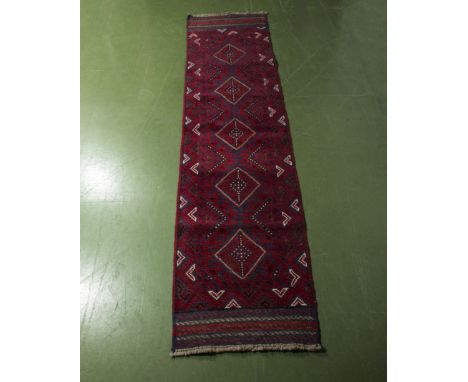 A hand knotted woolen red ground runner, 62cm x 249cm