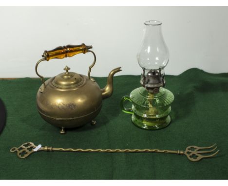A copper kettle with amber glass handle, toasting fork and a green glass oil lamp