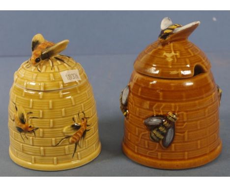 Two similar beehive form ceramic honey pots each with bee form finials to lid. Height 12cms & 13cms approx.