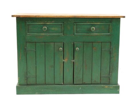 A pine and painted kitchen dresser base, the scrubbed top over two drawers and with cupboards beneath, raised on a plinth bas