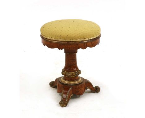 A George IV maple and parcel gilt piano stool, the adjustable upholstered seat on a turned base and scrolled feet, 45cm high 