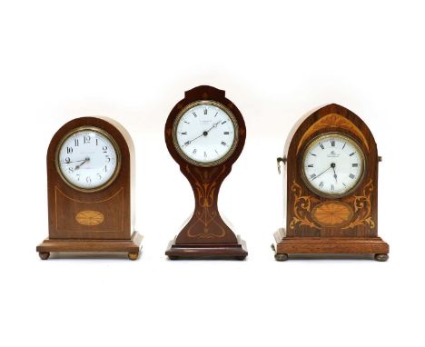 An Edwardian walnut lancet shaped mantle clock, by Finnigans of Manchester, with a white painted dial, the inlaid case raised