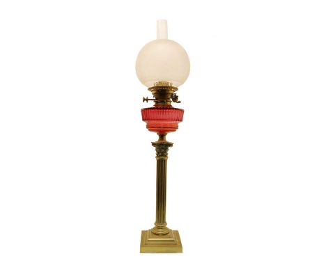 A brass duplex oil lamp, c.1900, the acid-etched shade decorated with birds over a ruby reservoir, on a Corinthian column sup