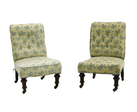 A pair of small Victorian low chairs by Cornelius and Smith, each with buttoned foliate upholstery, raised on turned mahogany