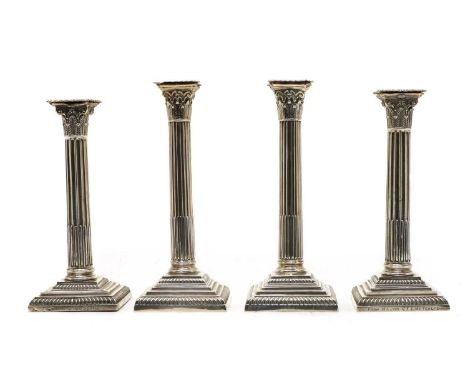 Two pairs of similar Victorian silver pillar candlesticks, with corinthian columns, on square stepped loaded bases, Sheffield