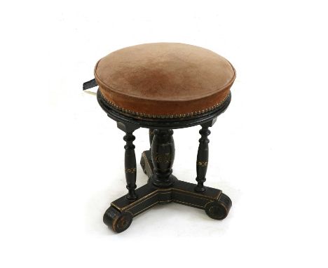 In the manner of Gillows of Lancaster, an Aesthetic period ebonised piano stool with an upholstered adjustable seat and incis