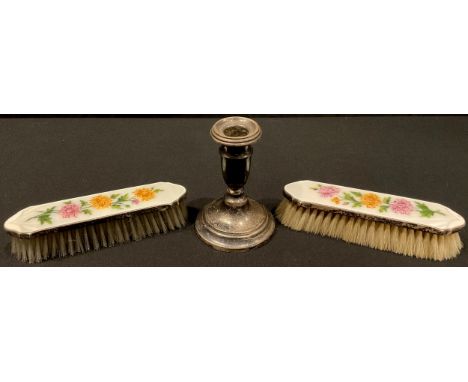 A pair of silver and enamel clothes brushes, Birmingham 1925; a silver candlestick, Birmingham 1921 (3) 