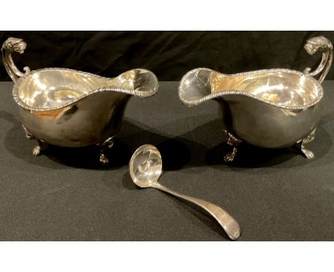 A pair of George V silver sauce boats, gadrooned borders, scroll handles with lion masks, each resting on three lion mask cab