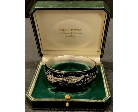 A Victorian silver and black enamel bangle, decorated with fanciful bird and inlaid with pearls 