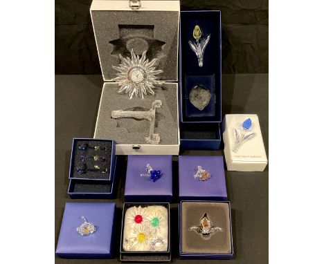 A collection of Swarovski Crystal clear and coloured ornaments, mostly flowers, including Solaris table clock, each boxed, qt