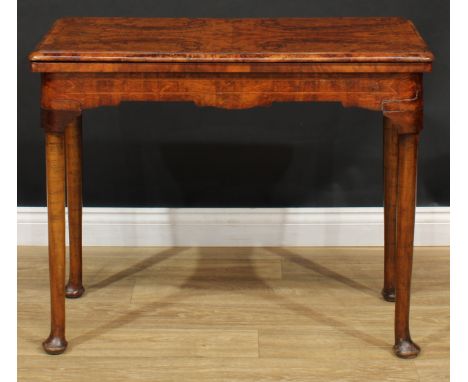 A walnut card table, hinged quarter-veneered top enclosing a baize-lined playing surface, cylindrical legs, pad feet, 74cm hi