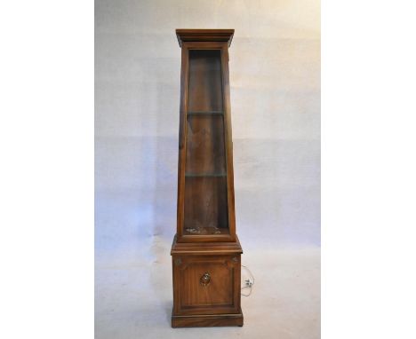 A walnut vitrine fitted with interior light and cupboard to the base. H.169 W.42 D.28cm 