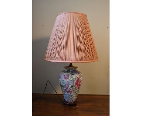 A 20th century Chinese style table lamp, decorated in floral design, along with a blush pleated shade. H.70 W.20cm (inc. shad