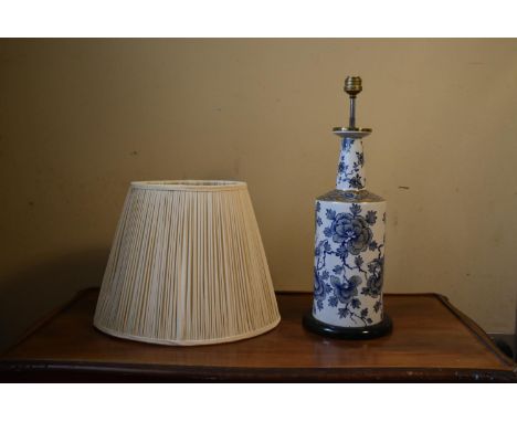 A contemporary blue and white table lamp, with floral decoration and a cream pleated shade. H.50 Dia.20cm (without shade) 