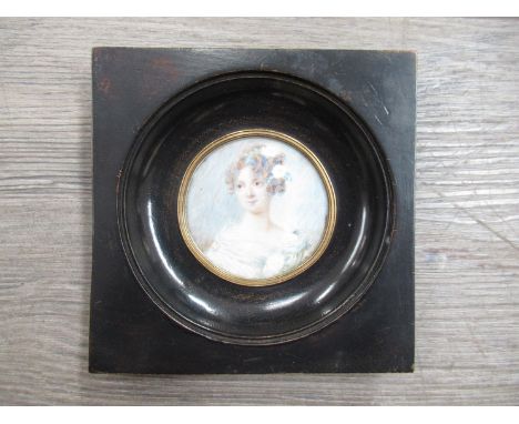 An early 20th Century school portrait miniature of a young lady, set in an ebonised frame. 5.5cm diameter