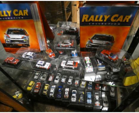 An extensive collection of scale model die cast rally cars in perspex cases 