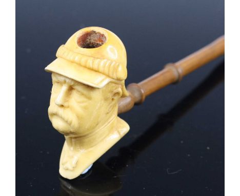 An early 20th century meerschaum pipe, the bowl carved as a bust of Bismarck, on a probably associated stem, 14cm, together w