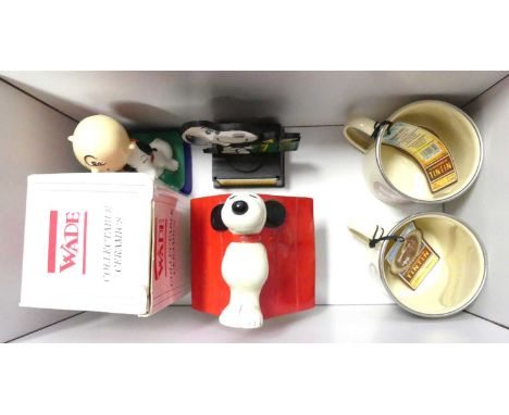 A collection of miscellaneous items, to include a Snoopy money-box, two Tintin enamelled metal mugs, and a Wade figure