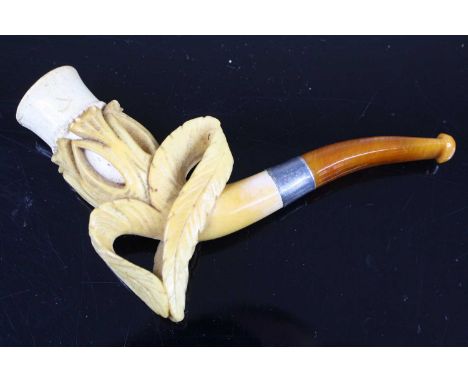 A 19th century meerschaum pipe, the bowl carved as a budding flowerhead. having a white metal collar and amber mouthpiece, 11