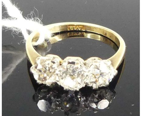 An 18ct gold platinum and diamond set three stone ring, the three claw set old European cuts in a line setting, total diamond