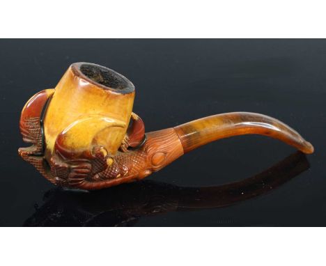 A late 19th century carved meerschaum pipe, the bowl held in the claws of an eagle's talons, 12cm, together with two other si