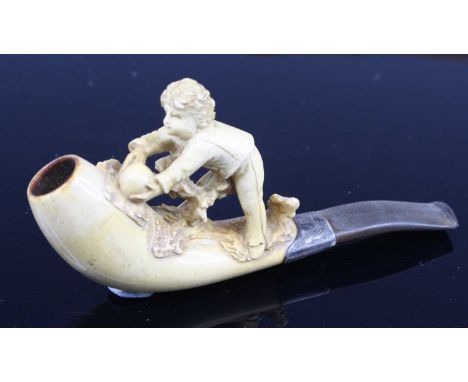 A 19th century meerschaum pipe, the bowl carved as a boy upon a branch, having an engraved white collar, 12cm, together with 