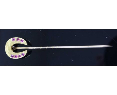 A yellow metal horseshoe tie-pin, the horseshoe set with seven cushion cut pink sapphires, horseshoe tests as approx 18ct gol