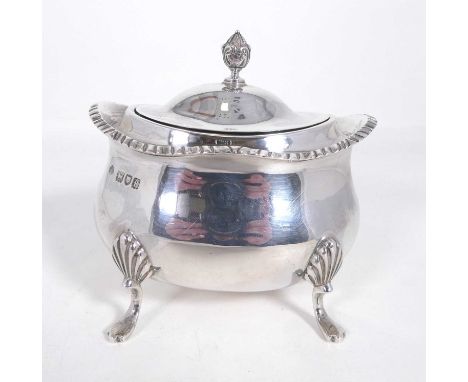 An Edwardian silver sugar basin, having a hinged cover with pineapple finial, over a lower bellied body on pad feet, William 