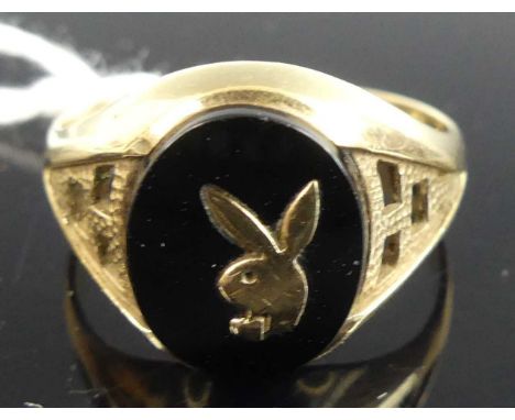 A gent's 9ct gold black agate set signet ring, the agate tablet with applied gold Playboy bunny ears, size R, 3.1g