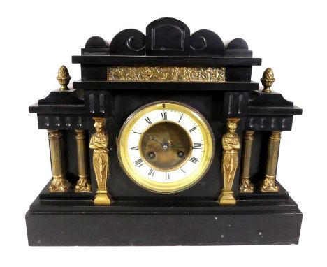 A late 19th century black slate mantel clock, of architectural form, having an enamelled chapter ring showing Roman numerals,