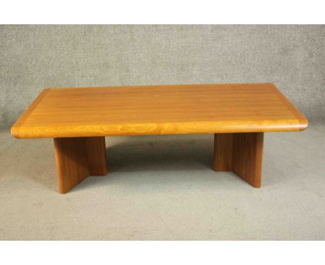 A 1970s vintage Danish teak coffee table on shaped block end supports. H.40 W.135 D.75cm. 