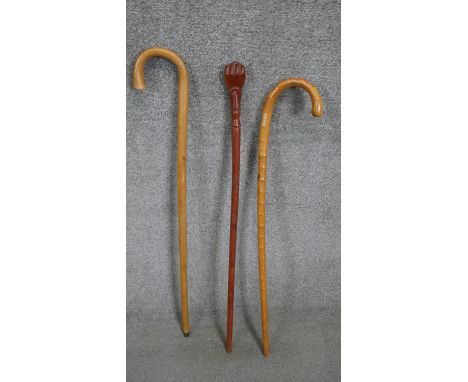 Three vintage walking sticks including a carved walking stick with a clenched fist top. H.93cm 