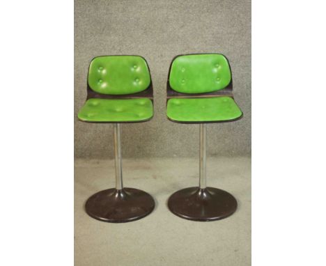 A pair of vintage bar stools in buttoned lime vinyl. 