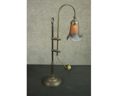 An Edwardian style brass desk lamp with polychrome glass shade on an adjustable mount and a circular base. H.67 W.35cm. 