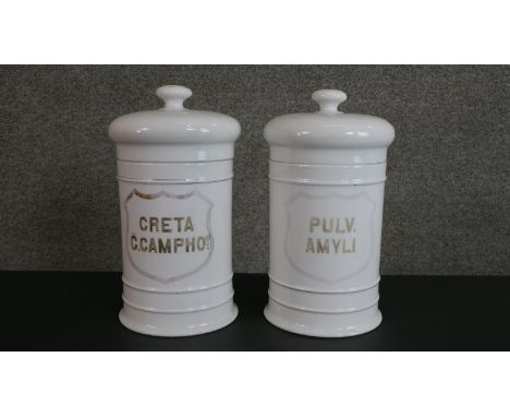 Two large 19th century white ceramic lidded apothecary jars, gilded Latin lettering with a shield cartouche 'Pulv Amyli' and 