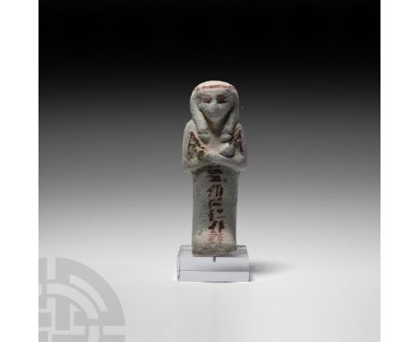 Third Intermediate Period, 21st Dynasty, 1069-943 B.C. A pale-coloured glazed shabti modelled with crossed arms and a wig, de