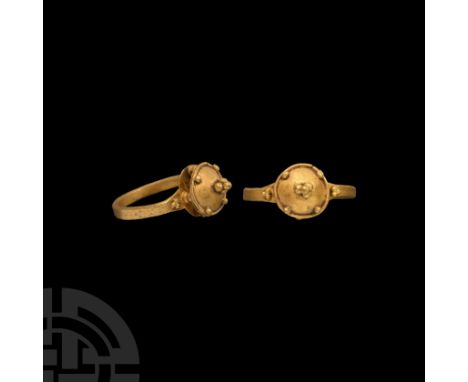 Circa 7th century A.D. A gold finger ring with flat-section hoop, round plaque with openwork 'architectural' bezel, dome with