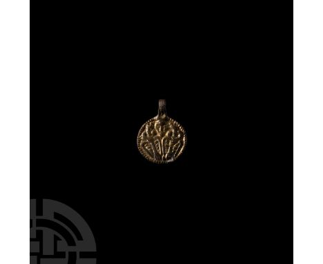 9th-10th century A.D. A gilt silver pendant of discoid form with integral suspension loop, displaying the god Odin in the cen