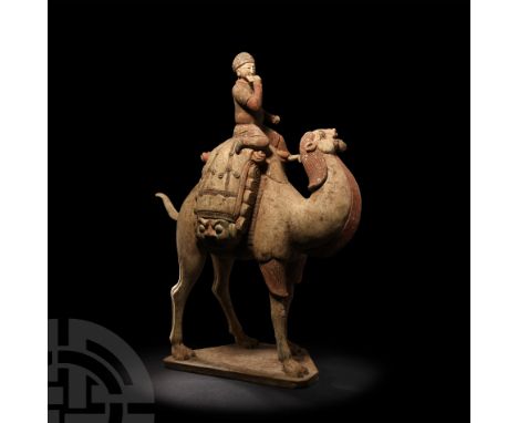 Tang Dynasty, 618-907 A.D. A terracotta Bactrian camel modelled in the round advancing on a polygonal base, head tossed backw