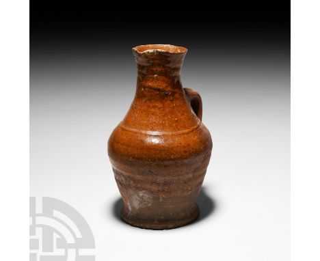 15th-16th century A.D. A wheel-thrown redware flask composed of a stout, piriform body, strap handle and pinched mouth, splay