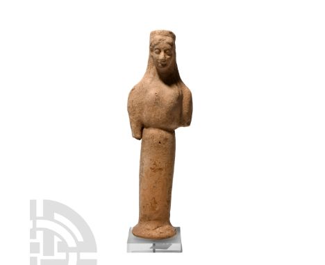6th-5th century B.C. A terracotta figure modelled as a kore standing facing on an integral splayed base, wearing a polos and 