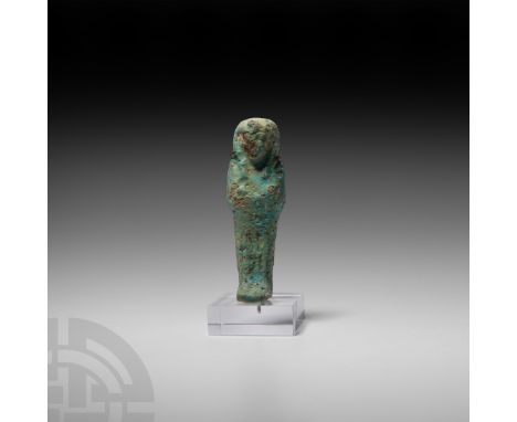 Third Intermediate Period, 22nd Dynasty, 945-720 B.C. A glazed composition shabti with seed basket painted to reverse, uraeus