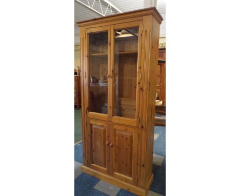 A Glazed Pine Three Shelf Bookcase with Cupboard Base. 