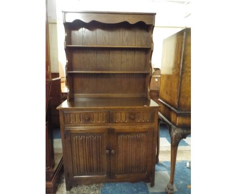 An Oak Linen Fold Dresser with Two Shelf Plate Rack. 