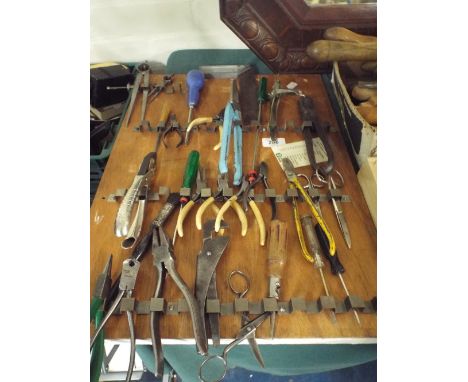 A Wall Hanging Rack Containing Clock Makers Tools, Pliers and Snips. 