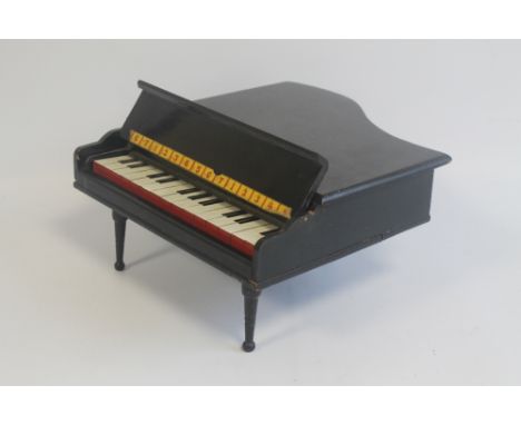 A BLACK PAINTED MINIATURE GRAND PIANO playing on bells