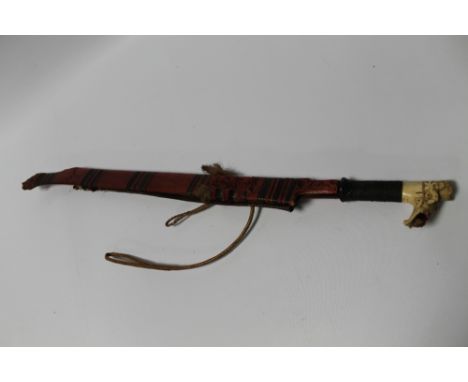 A DAYAK HEAD HUNTERS SWORD, with carved wood scabbard, woven grip and carved bone pommel, L 77.5 cm