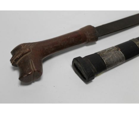 AN UNUSUAL DYAK DAGGER, the hilt carved with an animals head. The scabbard with white metal bands. L.42cm