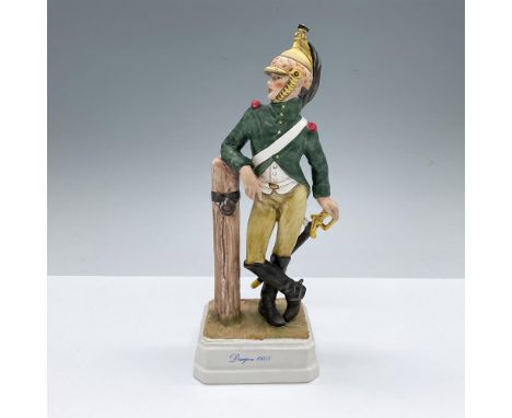Hand decorated figure of a soldier in dress green uniform, leaning on a post and hand resting on the handle of the sword. Art